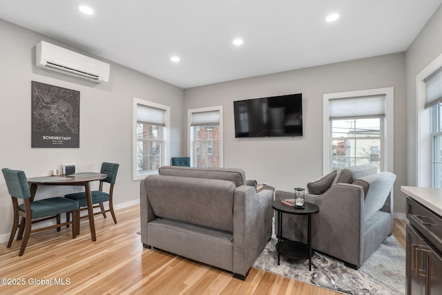 living room featuring light wood-type flooring and a wall mounted AC