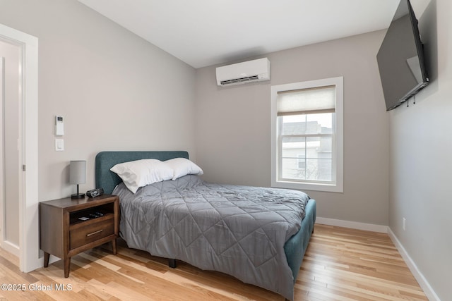 bedroom featuring wood-type flooring and a wall mounted AC