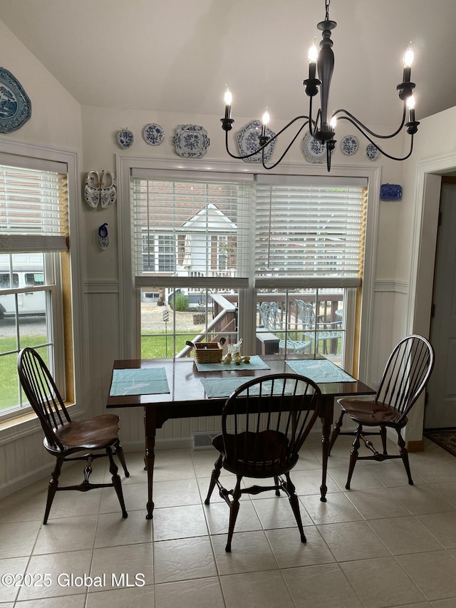 tiled dining area with an inviting chandelier, lofted ceiling, and plenty of natural light