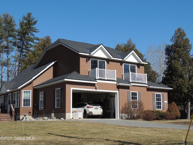 view of front facade featuring a garage, a front yard, and a balcony