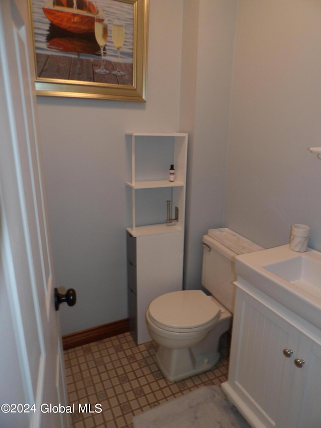 bathroom with toilet, tile patterned floors, and vanity