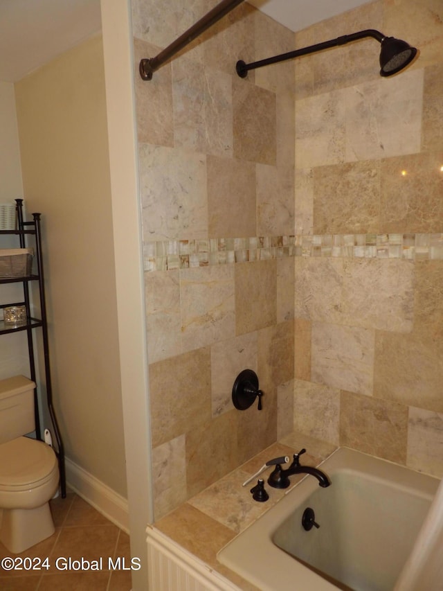 bathroom with toilet, tiled shower / bath combo, and tile patterned floors