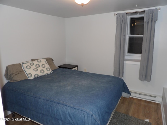 bedroom with dark hardwood / wood-style flooring and a baseboard radiator