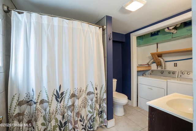 bathroom featuring toilet, vanity, tile patterned flooring, and washer and dryer