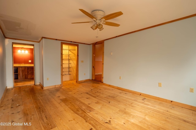 unfurnished bedroom with ceiling fan, light wood-type flooring, a closet, ornamental molding, and a walk in closet