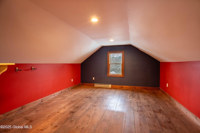 additional living space featuring light hardwood / wood-style floors, a baseboard radiator, and lofted ceiling