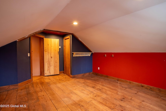 bonus room featuring light wood-type flooring and vaulted ceiling