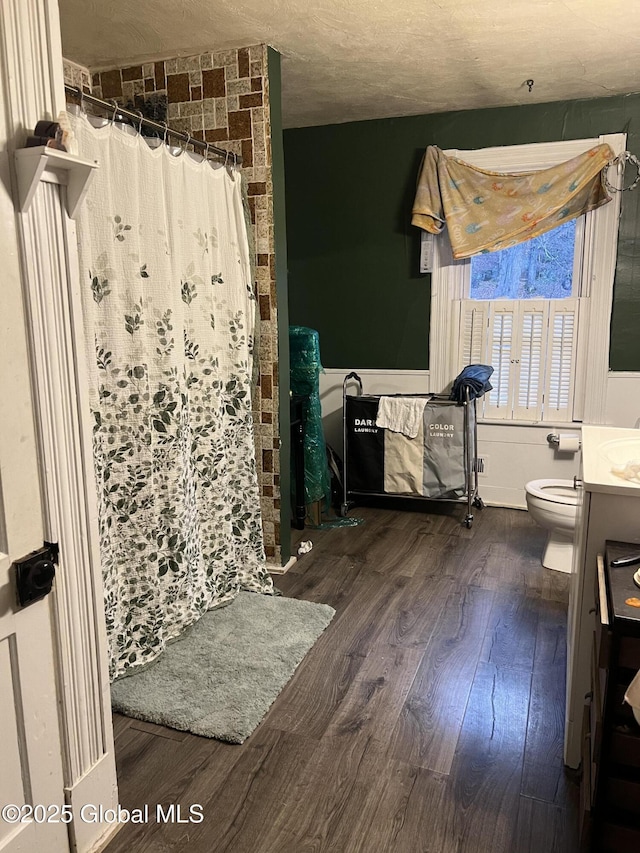 bathroom with toilet, vanity, walk in shower, hardwood / wood-style floors, and a textured ceiling