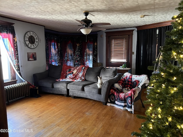 living room with ceiling fan, radiator, and hardwood / wood-style flooring