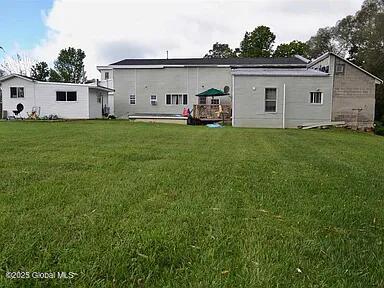 back of house featuring a lawn