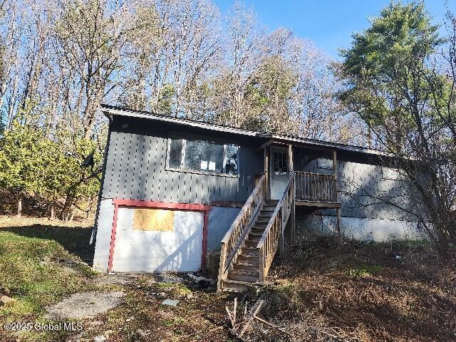 view of front of property with stairway and metal roof