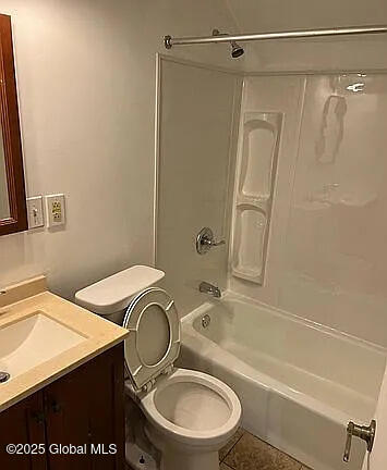 full bathroom with toilet, tile patterned floors, vanity, and  shower combination