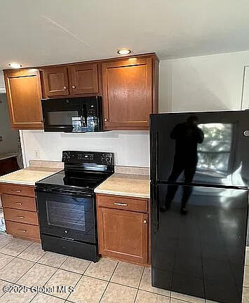 kitchen featuring light tile patterned flooring and black appliances