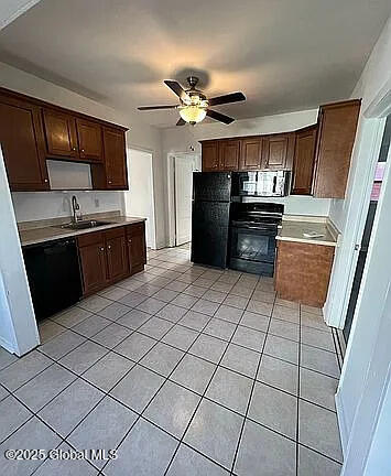 kitchen with black appliances, light tile patterned floors, ceiling fan, and sink