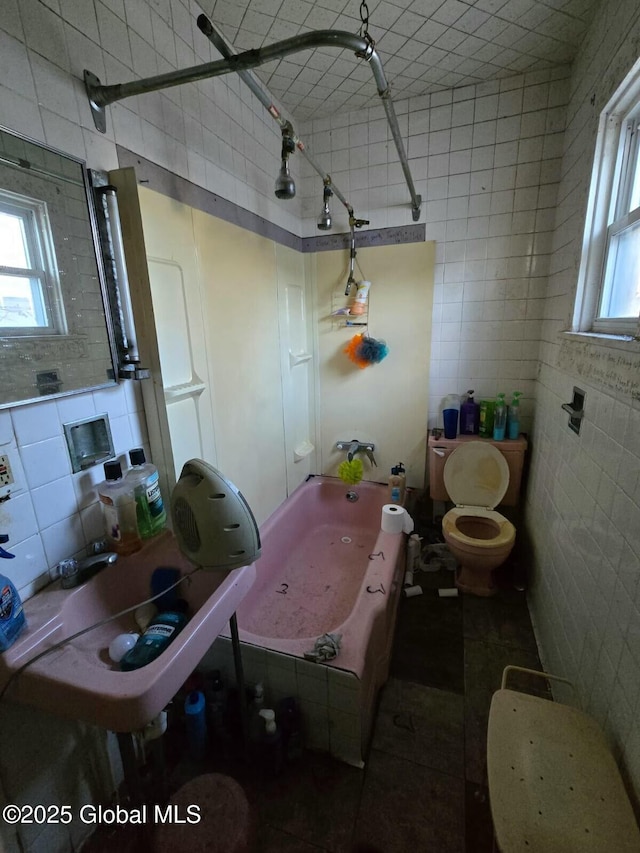 bathroom with toilet, tile walls, decorative backsplash, and walk in shower