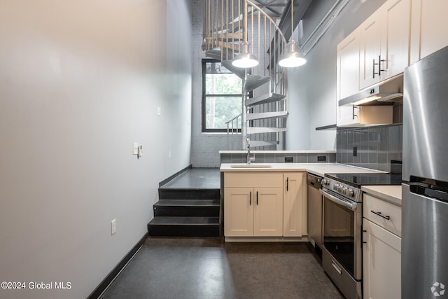 kitchen featuring sink, decorative light fixtures, white cabinetry, and appliances with stainless steel finishes