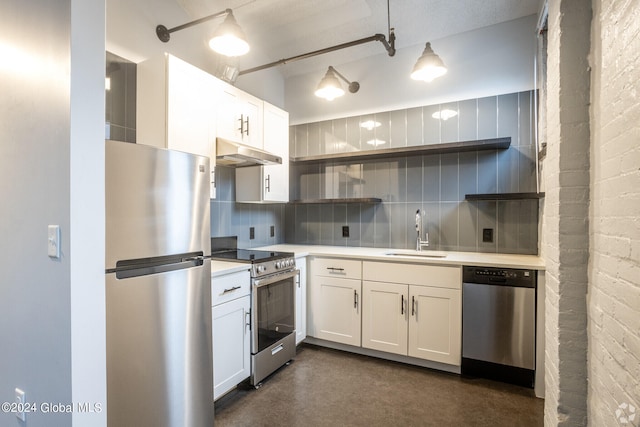 kitchen with sink, backsplash, white cabinetry, and appliances with stainless steel finishes