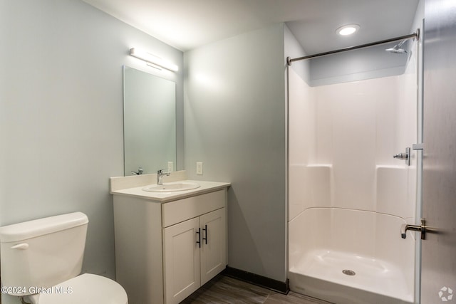 bathroom with a shower, toilet, and vanity