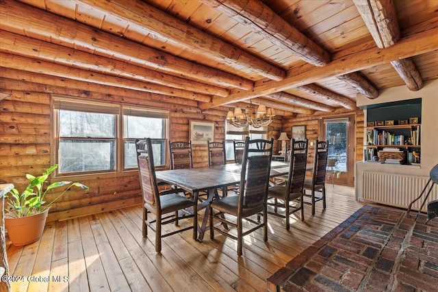 dining space with radiator, beamed ceiling, rustic walls, a notable chandelier, and wooden ceiling