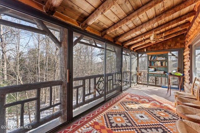 sunroom / solarium featuring vaulted ceiling with beams, wood ceiling, and a healthy amount of sunlight