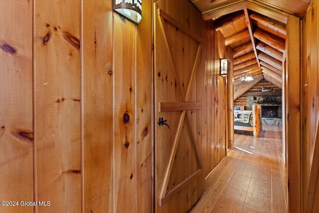 hallway featuring hardwood / wood-style floors and vaulted ceiling