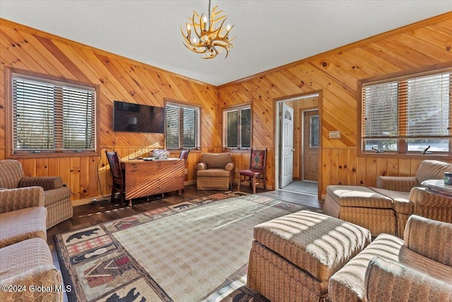 living room with wood walls, an inviting chandelier, a wealth of natural light, and dark hardwood / wood-style flooring