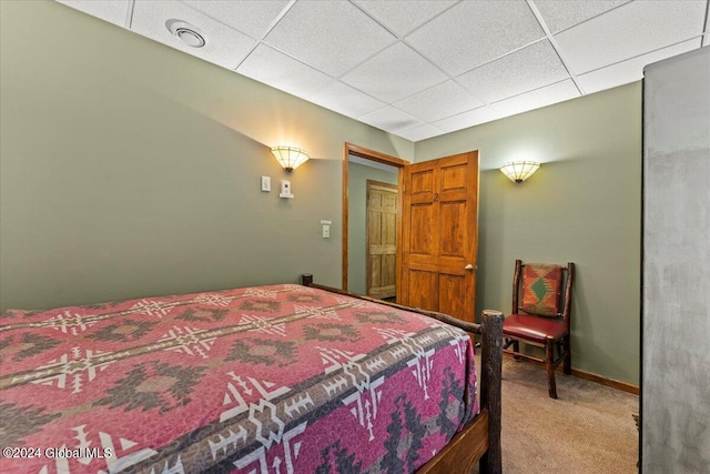 bedroom with carpet floors and a paneled ceiling