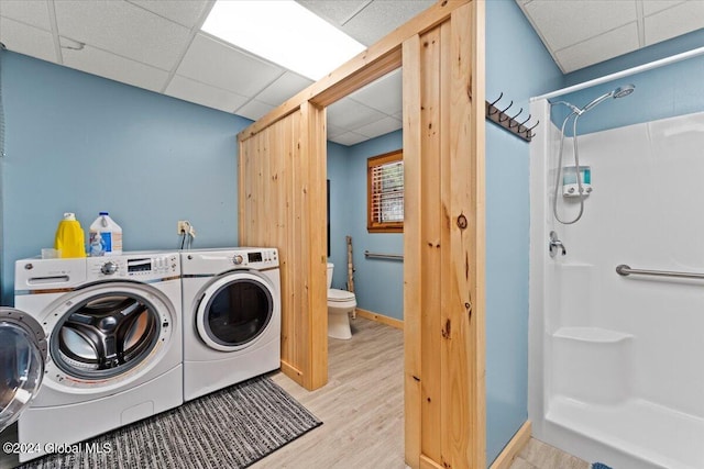 clothes washing area featuring independent washer and dryer and light hardwood / wood-style flooring