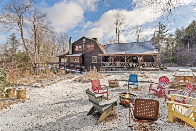 snow covered house featuring an outdoor fire pit