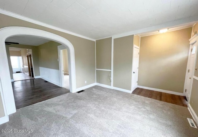 empty room featuring dark carpet and ornamental molding