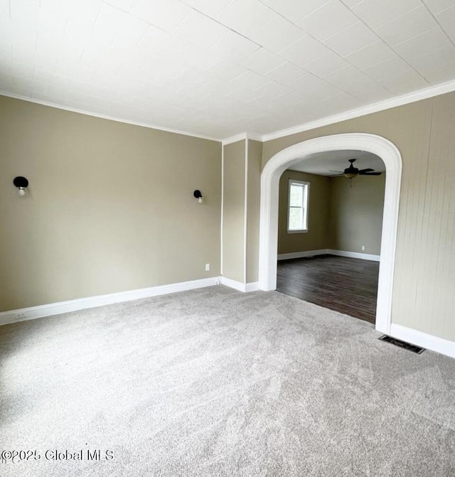 carpeted empty room featuring ceiling fan and ornamental molding