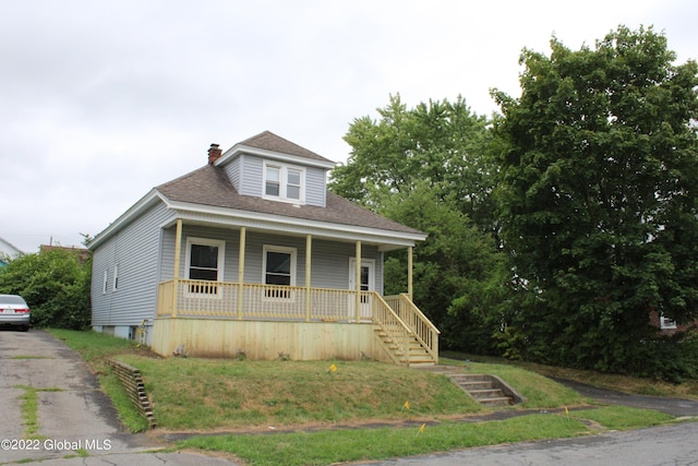 view of front of property with covered porch and a front lawn