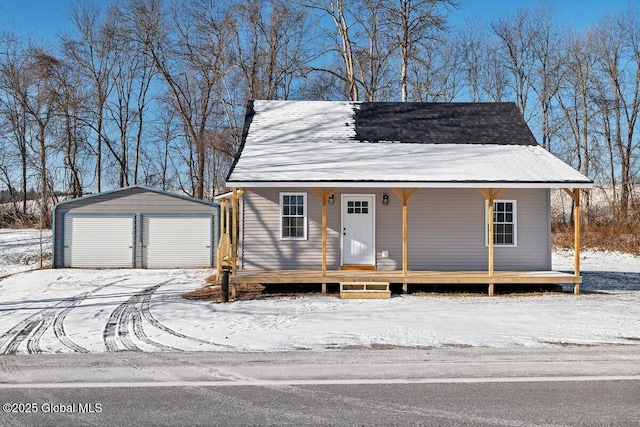 view of front facade featuring a garage, a porch, and an outbuilding