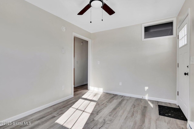 unfurnished room featuring ceiling fan, a baseboard heating unit, and light wood-type flooring