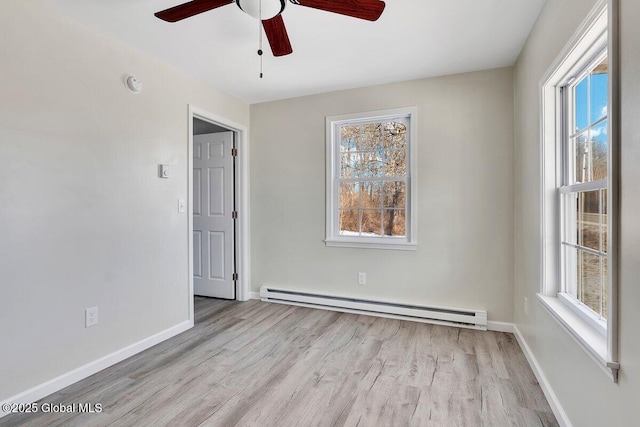 spare room featuring ceiling fan, a baseboard radiator, plenty of natural light, and light hardwood / wood-style floors