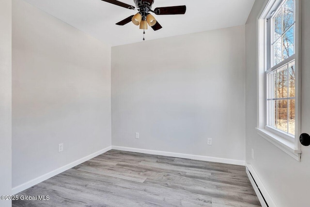 spare room featuring a baseboard radiator, ceiling fan, and light hardwood / wood-style floors