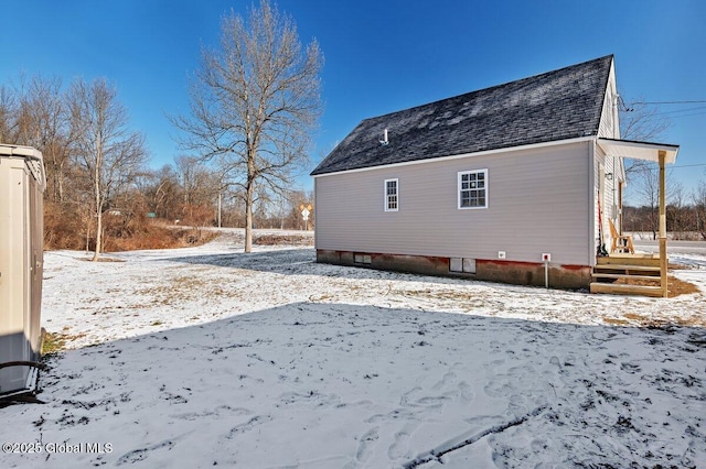 view of snow covered back of property