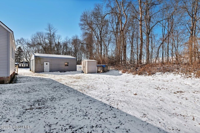 yard covered in snow with a storage shed