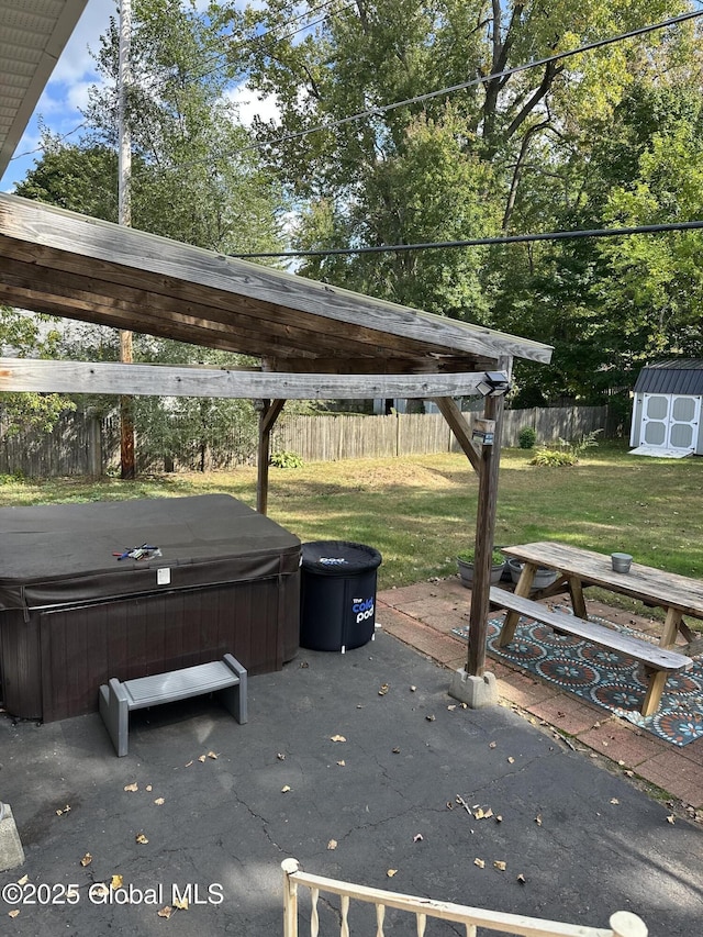 view of patio / terrace with a storage unit and a hot tub