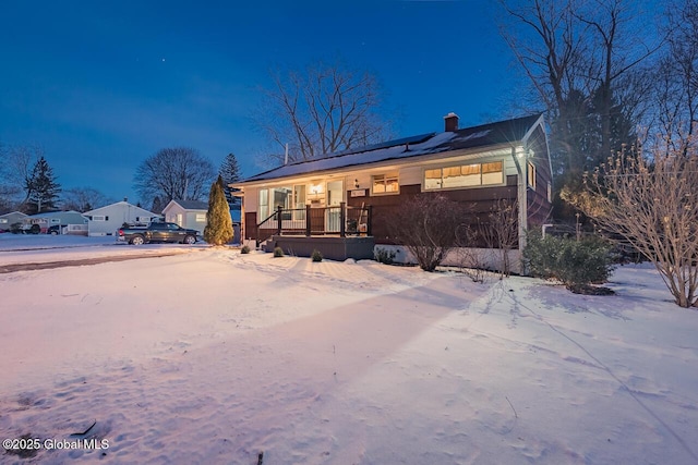 view of front of property featuring covered porch and solar panels