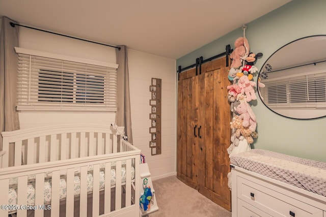 carpeted bedroom featuring a barn door