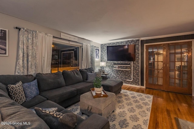 living room featuring french doors, brick wall, and hardwood / wood-style floors