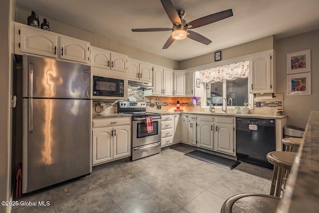 kitchen featuring white cabinetry, sink, decorative backsplash, light stone counters, and black appliances