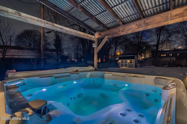 view of swimming pool featuring a storage shed and a hot tub