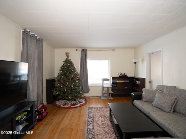 living room with hardwood / wood-style floors and crown molding