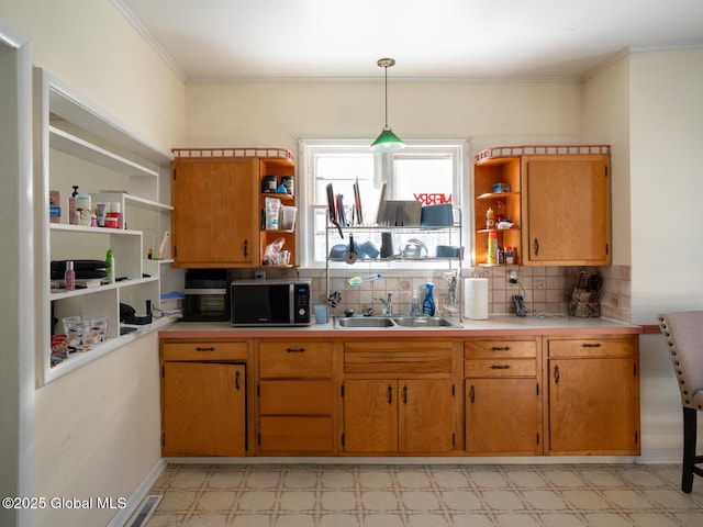 kitchen with crown molding, sink, decorative backsplash, and decorative light fixtures