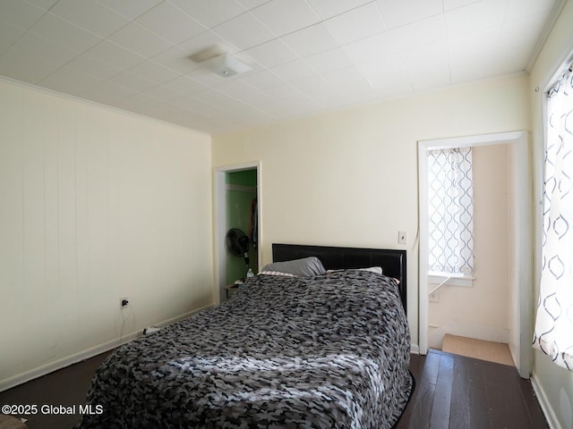 bedroom featuring multiple windows and dark hardwood / wood-style floors