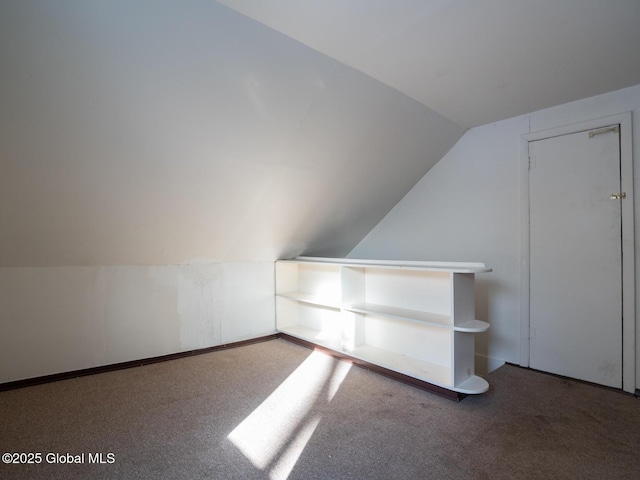 bonus room featuring dark carpet and vaulted ceiling