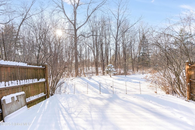 yard layered in snow with fence