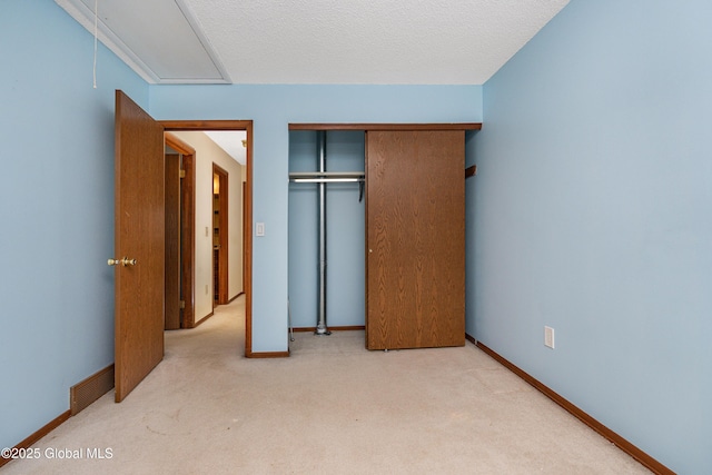 unfurnished bedroom with baseboards, visible vents, a closet, and light carpet